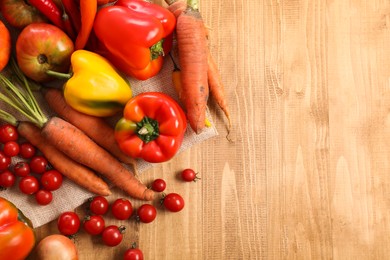 Different fresh ripe vegetables on wooden table, flat lay. Space for text