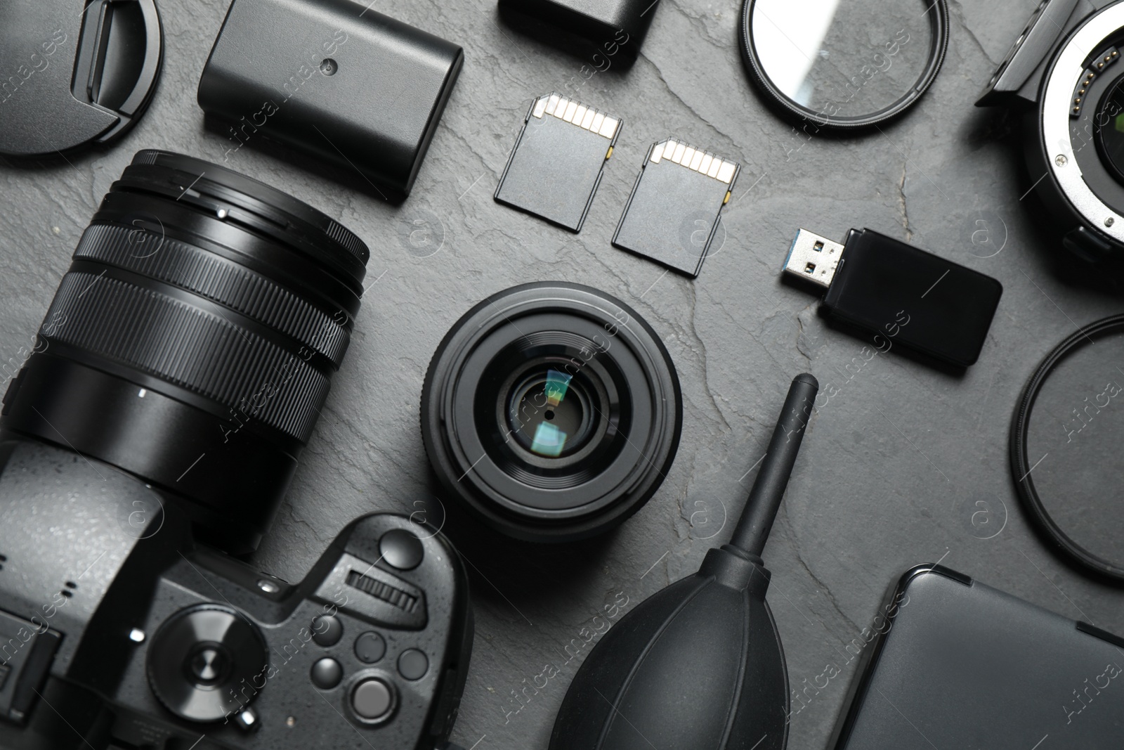 Photo of Flat lay composition with camera and video production equipment on grey stone background