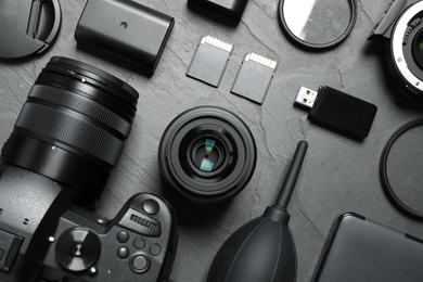 Flat lay composition with camera and video production equipment on grey stone background