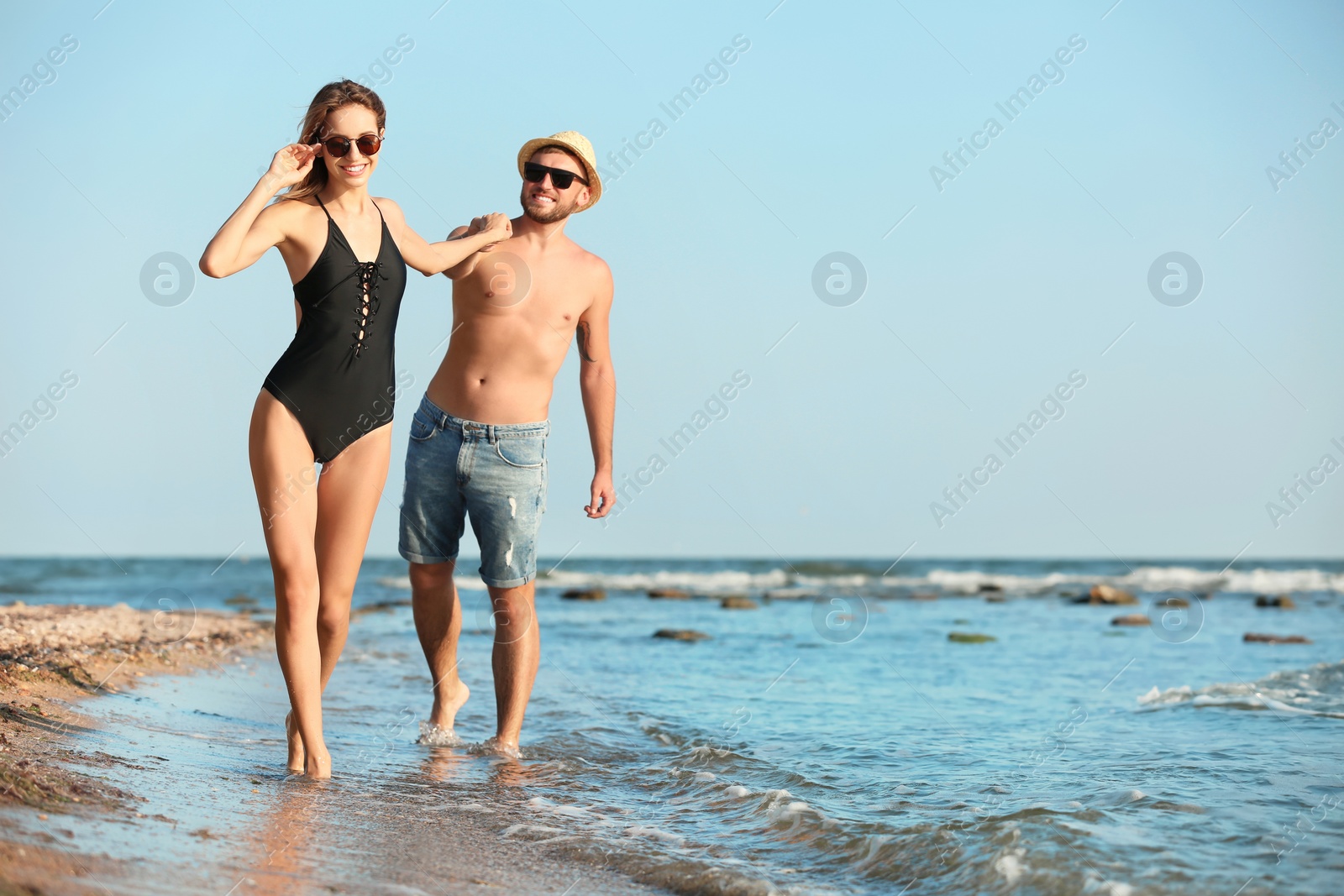 Photo of Young couple spending time together on beach