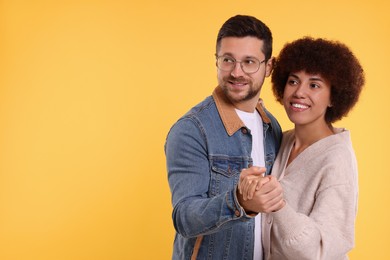 Photo of International dating. Lovely couple dancing on orange background, space for text