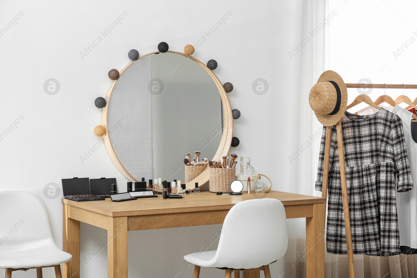 Photo of Cosmetics and brushes on dressing table in makeup room