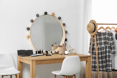 Photo of Cosmetics and brushes on dressing table in makeup room