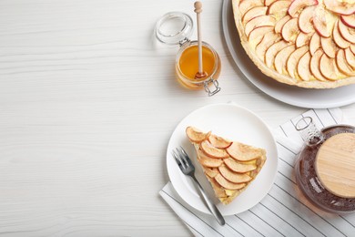 Freshly baked delicious apple pie served on white wooden table. Space for text