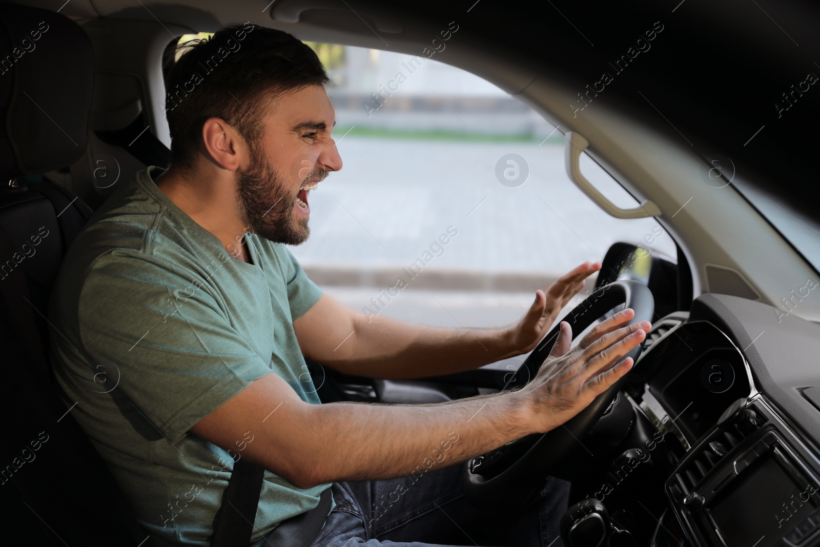 Photo of Emotional man in car. Aggressive driving behavior