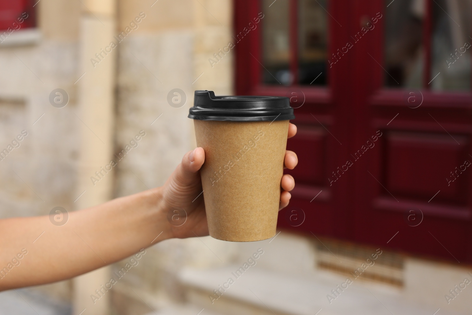 Photo of Coffee to go. Woman with paper cup of drink outdoors, closeup