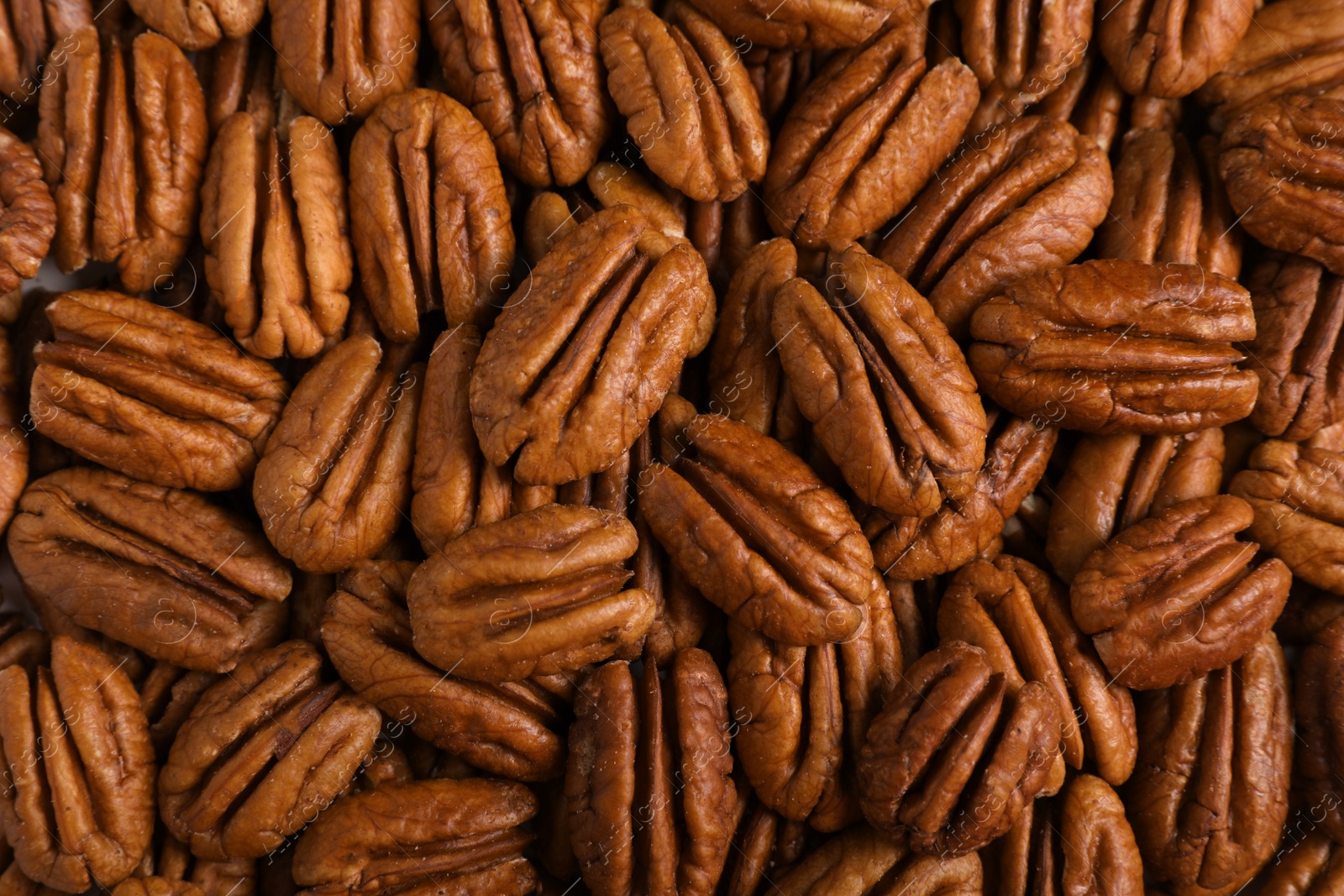 Photo of Tasty fresh ripe pecan nuts as background, top view