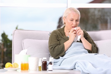Photo of Ill mature woman suffering from cough at home. Space for text