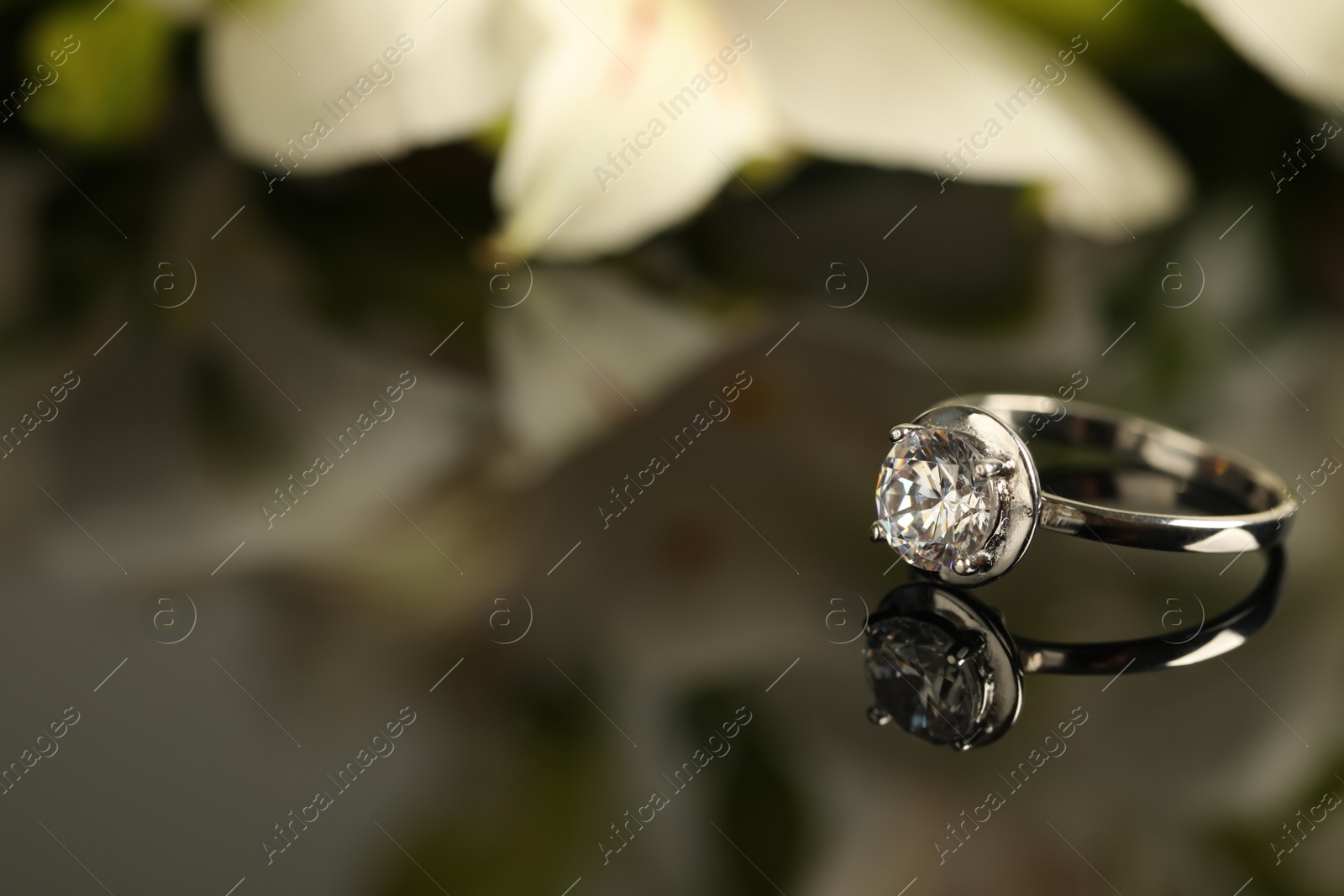 Photo of Beautiful engagement ring against blurred background, space for text