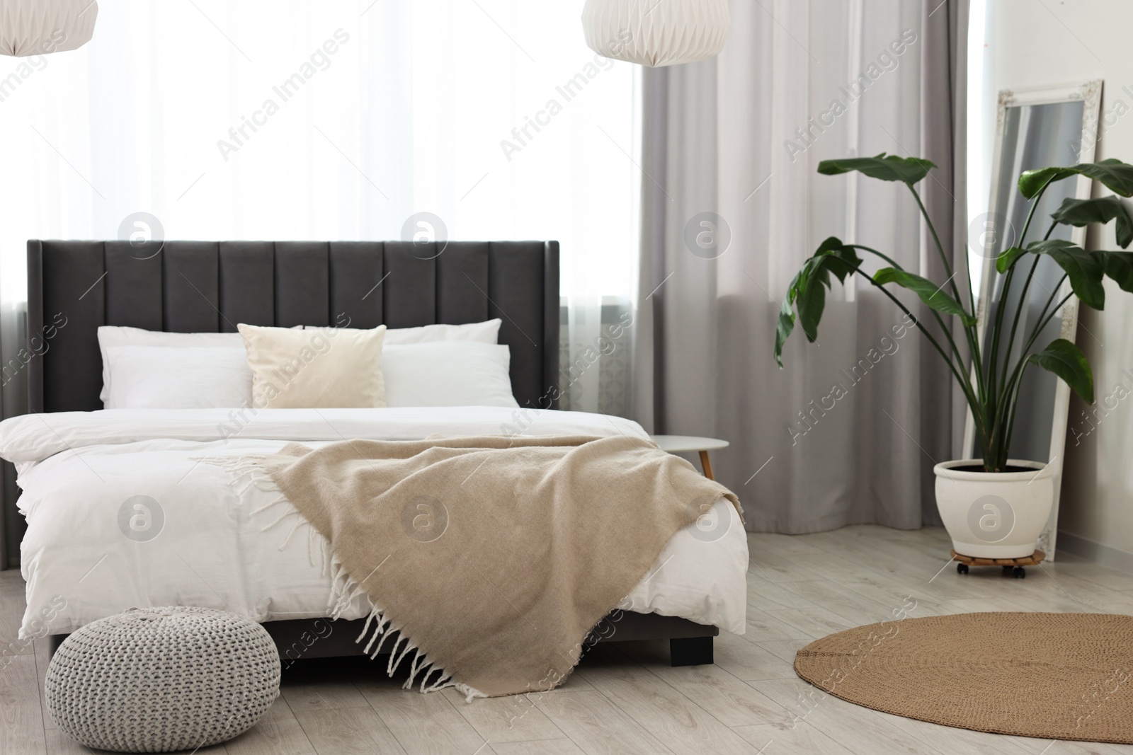 Photo of Soft beige plaid on bed in stylish bedroom. Interior design