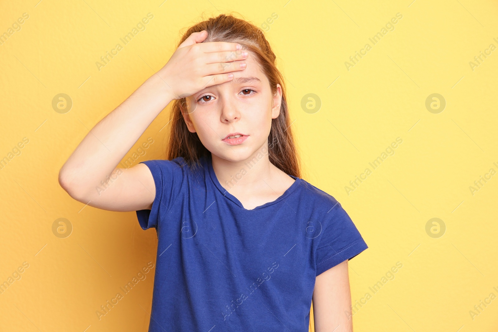 Photo of Little girl suffering from headache on color background