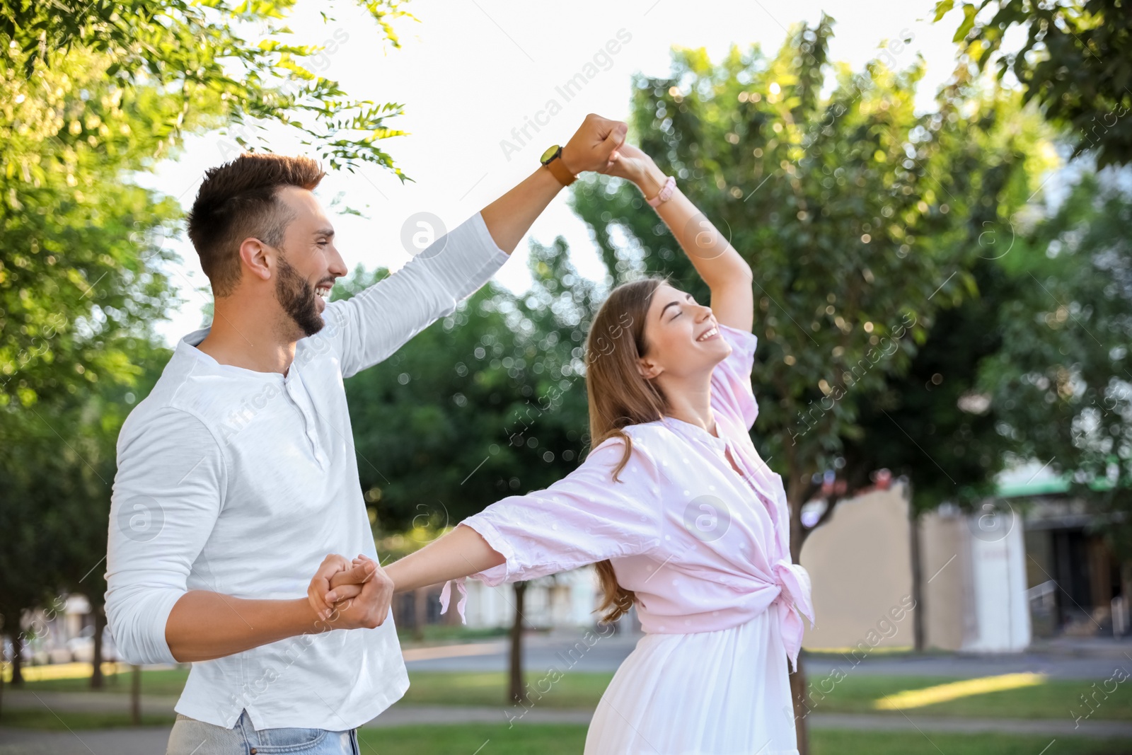 Photo of Lovely young couple dancing together in park on sunny day