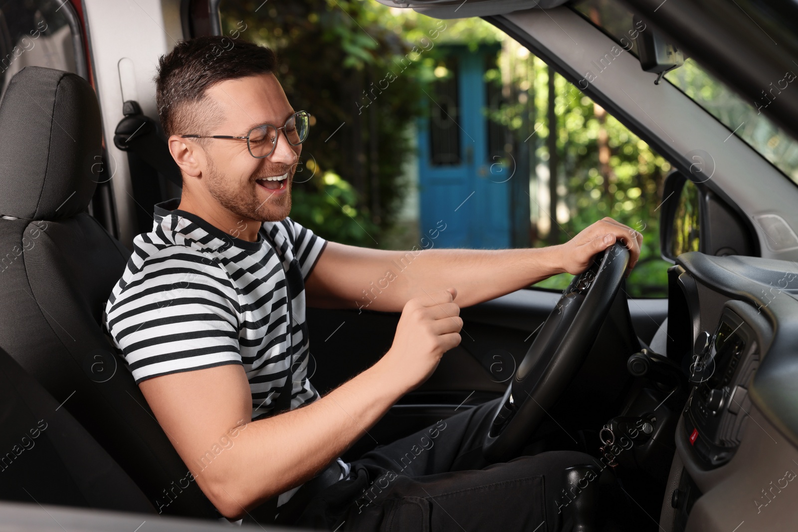 Photo of Listening to radio while driving. Handsome man enjoying music in car