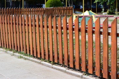 Wooden fence near mini golf court on sunny day outdoors