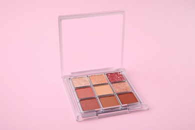Photo of Beautiful eye shadow palette on pink background
