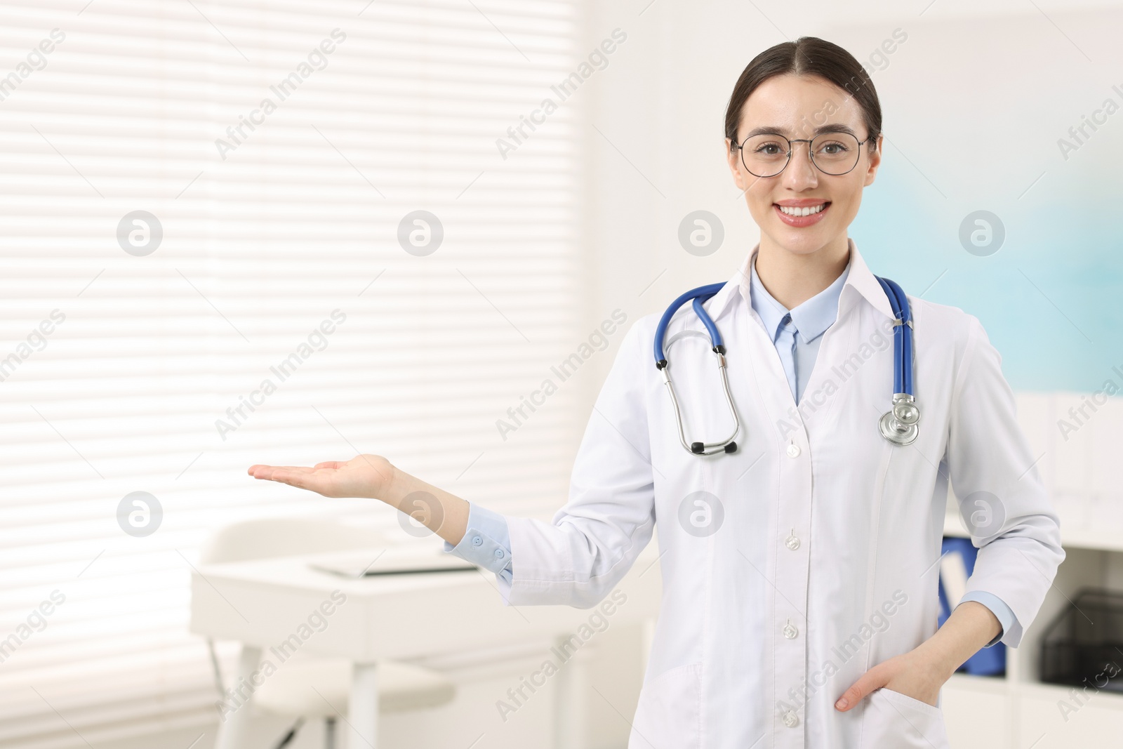 Photo of Medical consultant with glasses and stethoscope in clinic, space for text