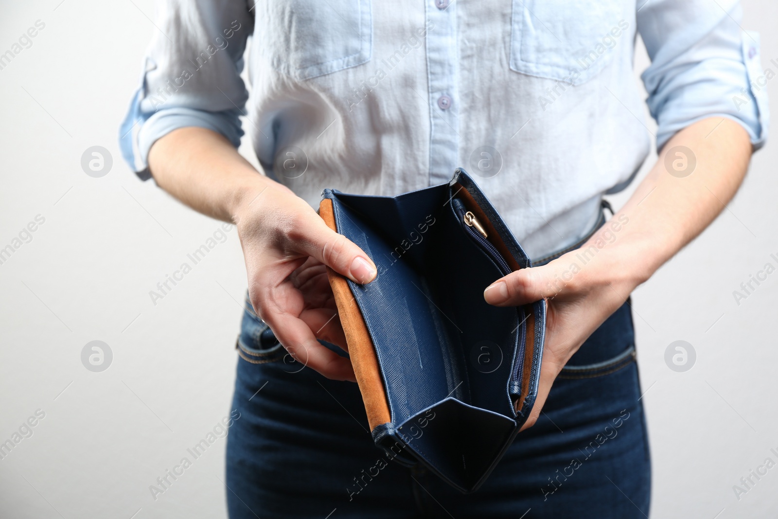 Woman showing empty wallet on light background, closeup Photo of Woman showing empty wallet on light background, closeup