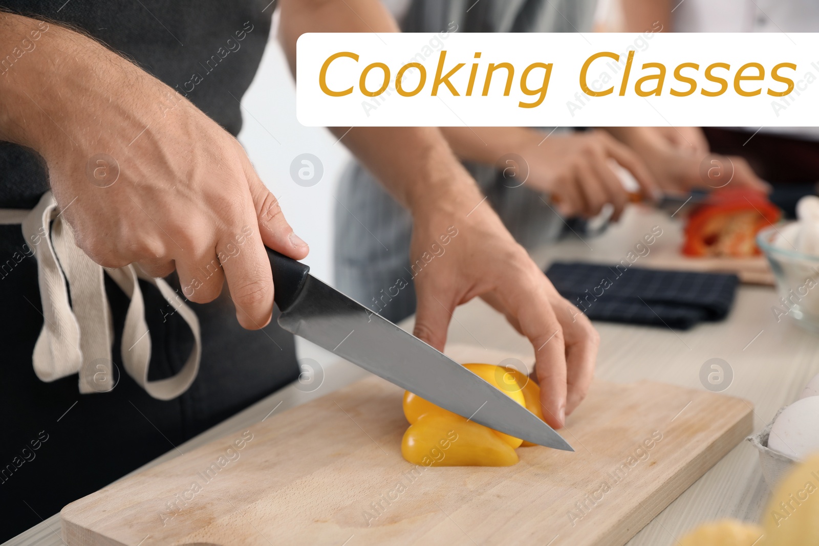 Image of Cooking classes. Man cutting paprika on wooden board at table, closeup