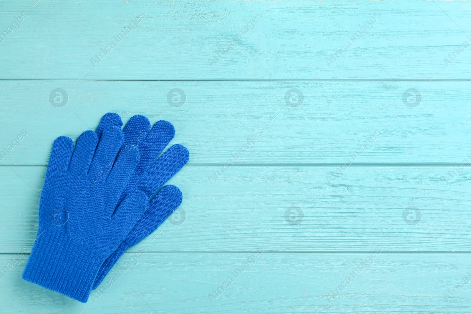 Photo of Stylish blue gloves on turquoise wooden background, flat lay. Space for text