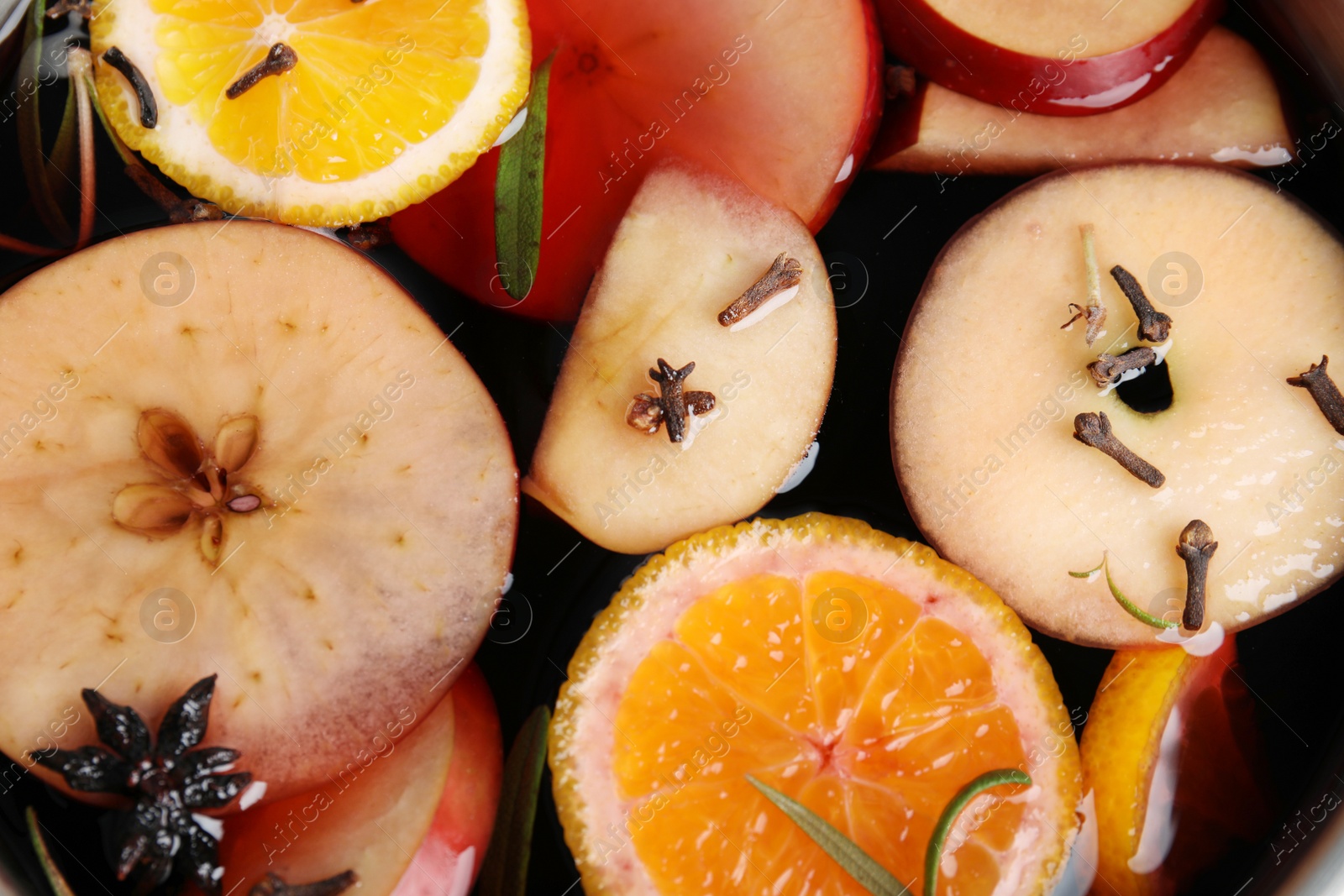 Photo of Tasty mulled wine with spices as background, closeup