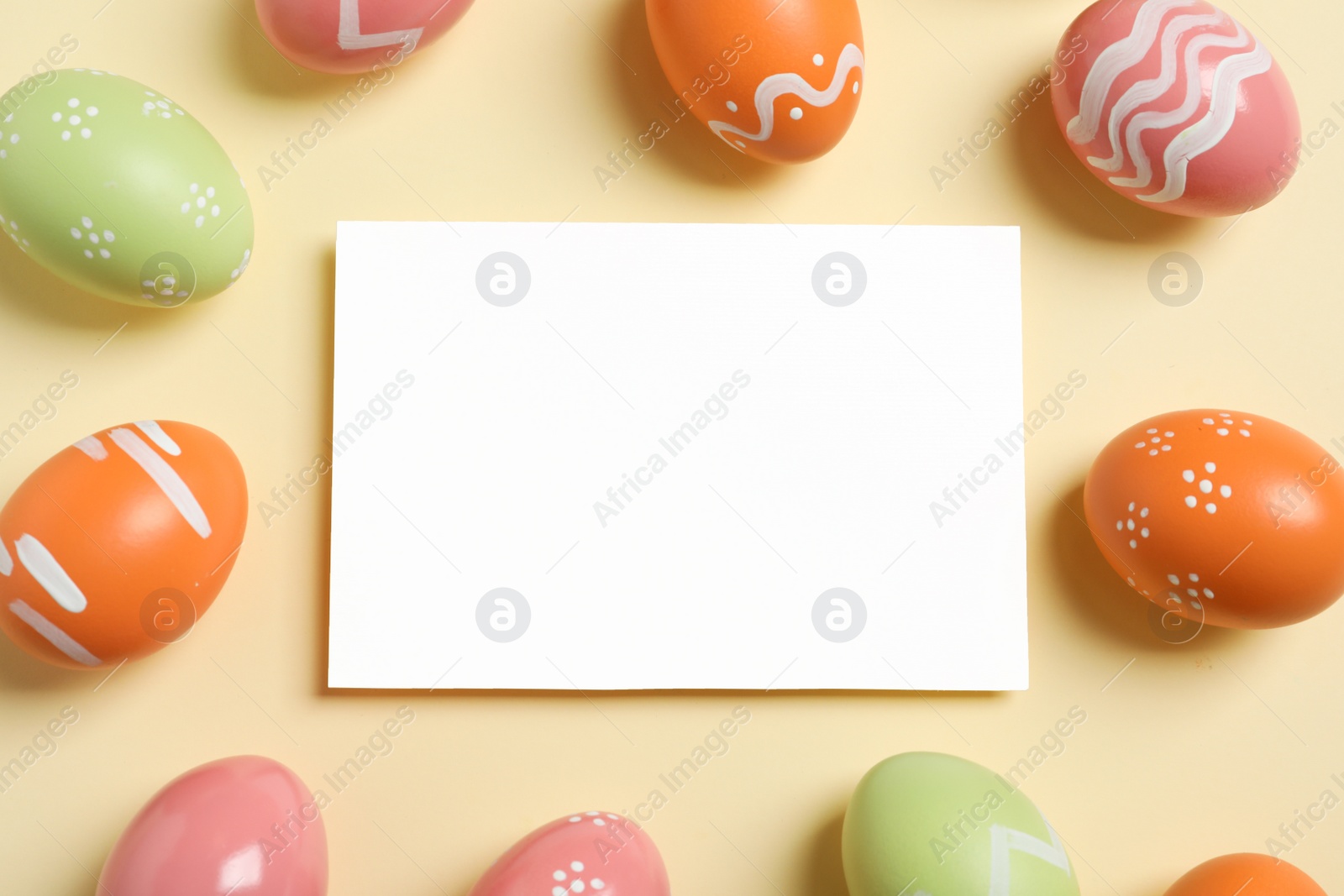 Photo of Flat lay composition of painted Easter eggs and blank card on color background, space for text