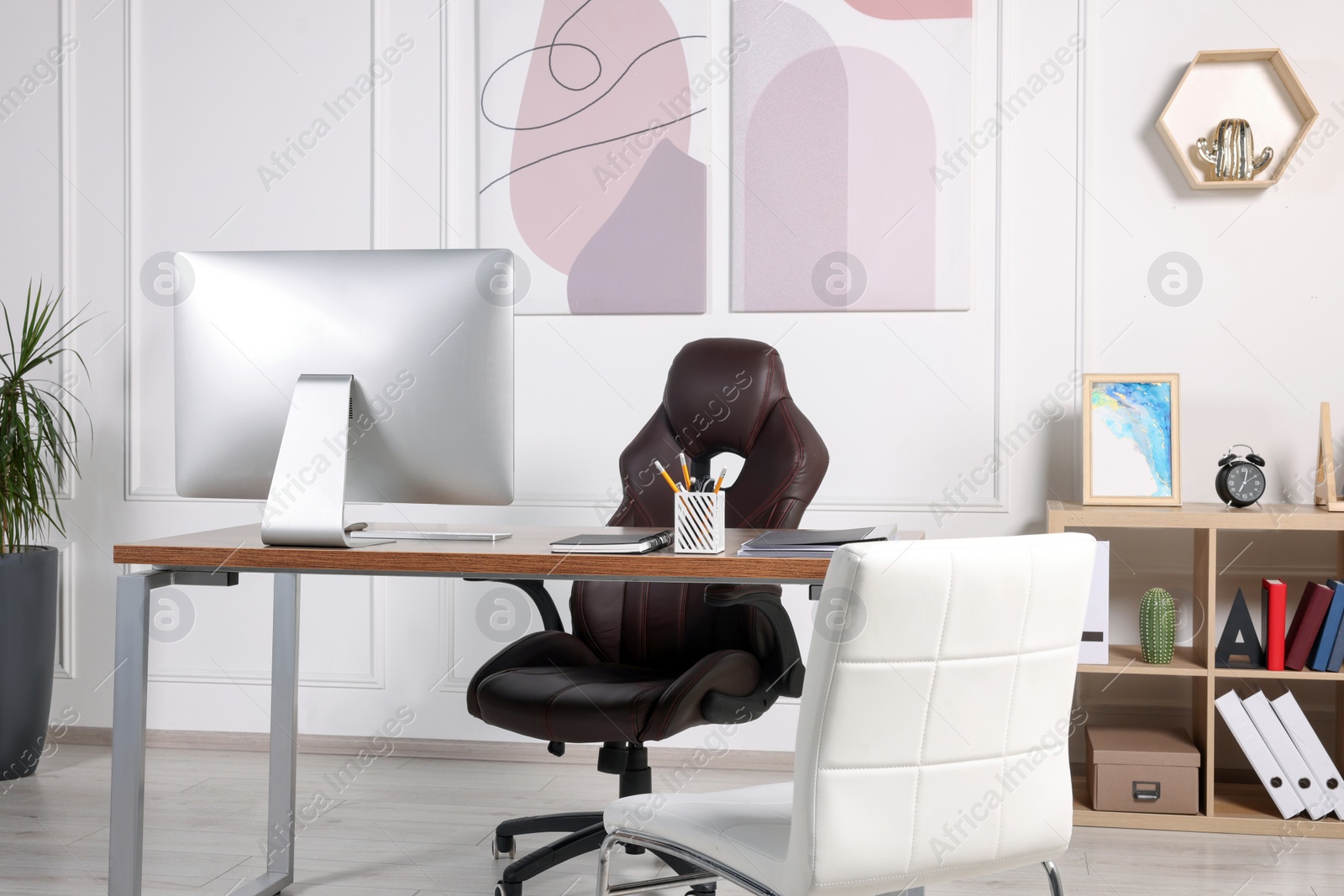 Photo of Director's workplace with wooden table, computer and comfortable armchairs. Interior design