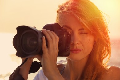 Image of Photographer taking photo with professional camera outdoors, closeup