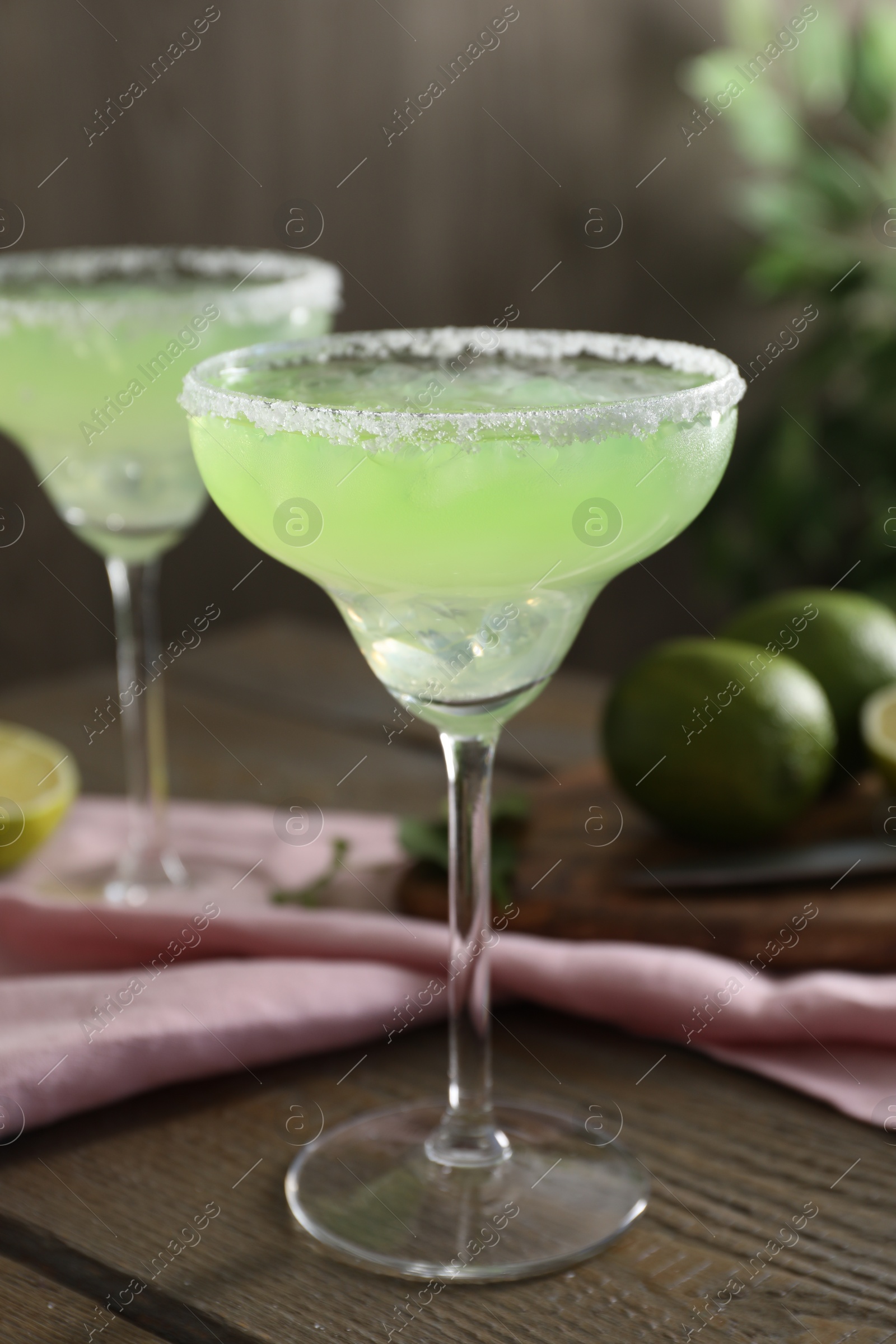 Photo of Delicious Margarita cocktail in glass on wooden table, closeup