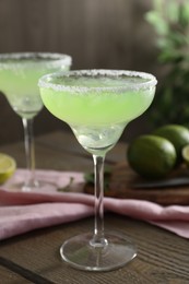 Photo of Delicious Margarita cocktail in glass on wooden table, closeup