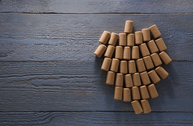 Grape made of wine bottle corks on grey wooden table, top view. Space for text