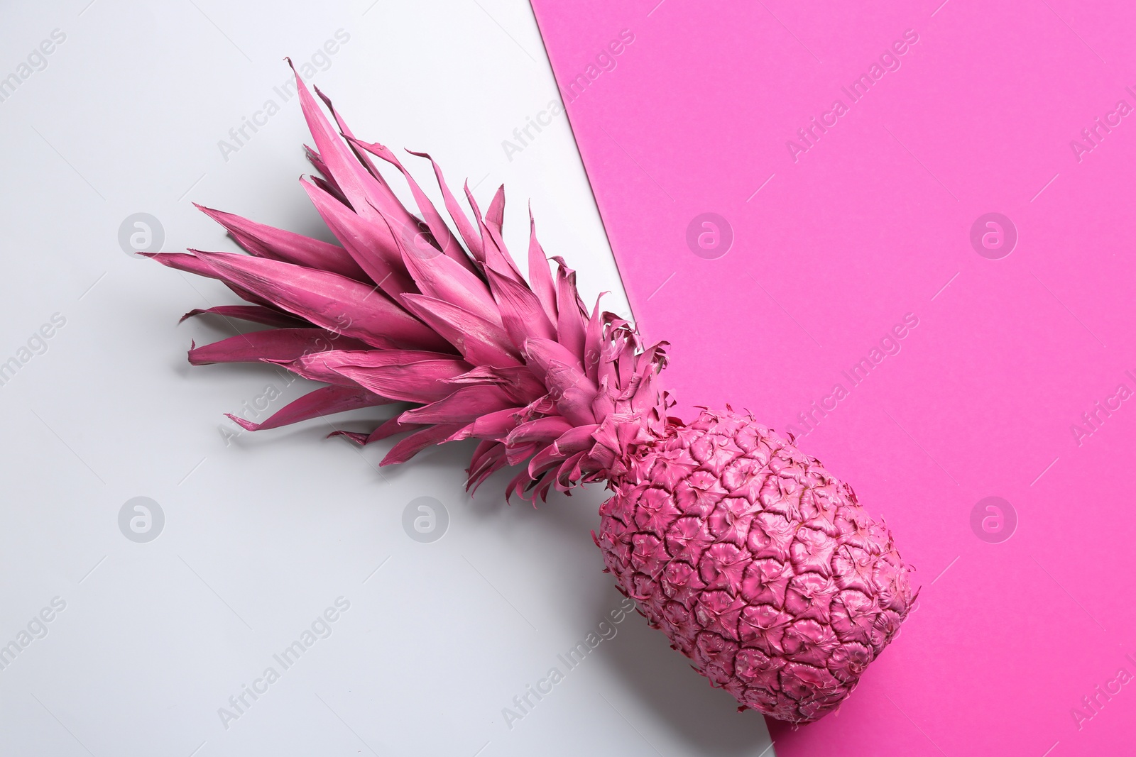 Photo of Pink pineapple on color background, top view. Creative concept