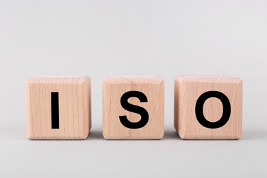 International Organization for Standardization. Cubes with abbreviation ISO on light grey background, closeup