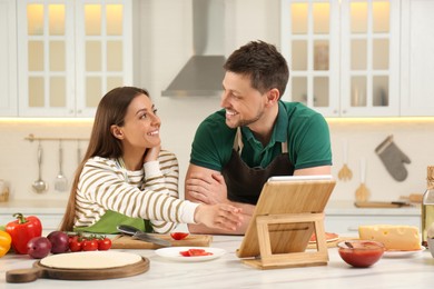 Couple watching online cooking course via tablet in kitchen