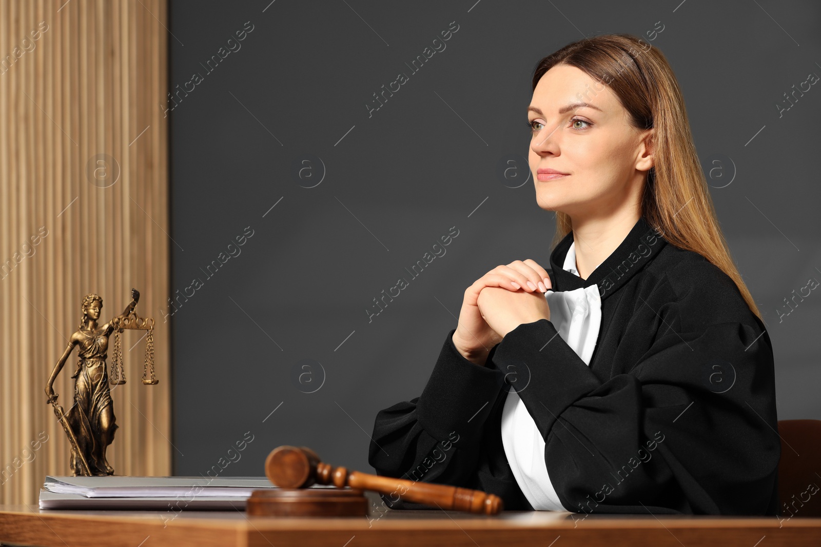 Photo of Judge working at table in courtroom, space for text