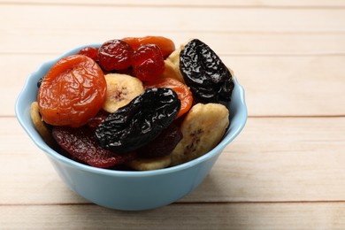 Photo of Mix of delicious dried fruits on white wooden table, closeup. Space for text