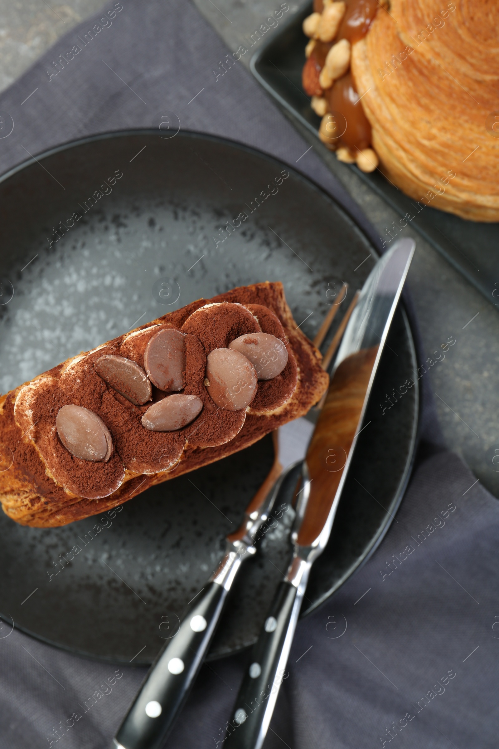 Photo of Round croissants served on grey table, flat lay. Tasty puff pastry