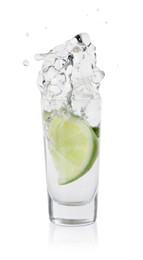 Vodka splashing out of shot glass with lime on white background