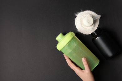 Photo of Woman with bottle of water, protein powder and space for text on black background, top view. Preparing shake