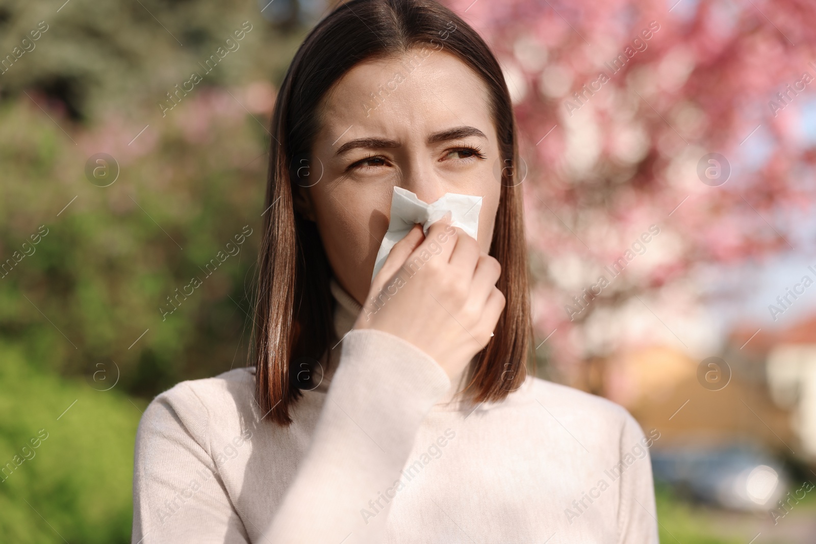 Photo of Woman with napkin suffering from seasonal allergy on spring day