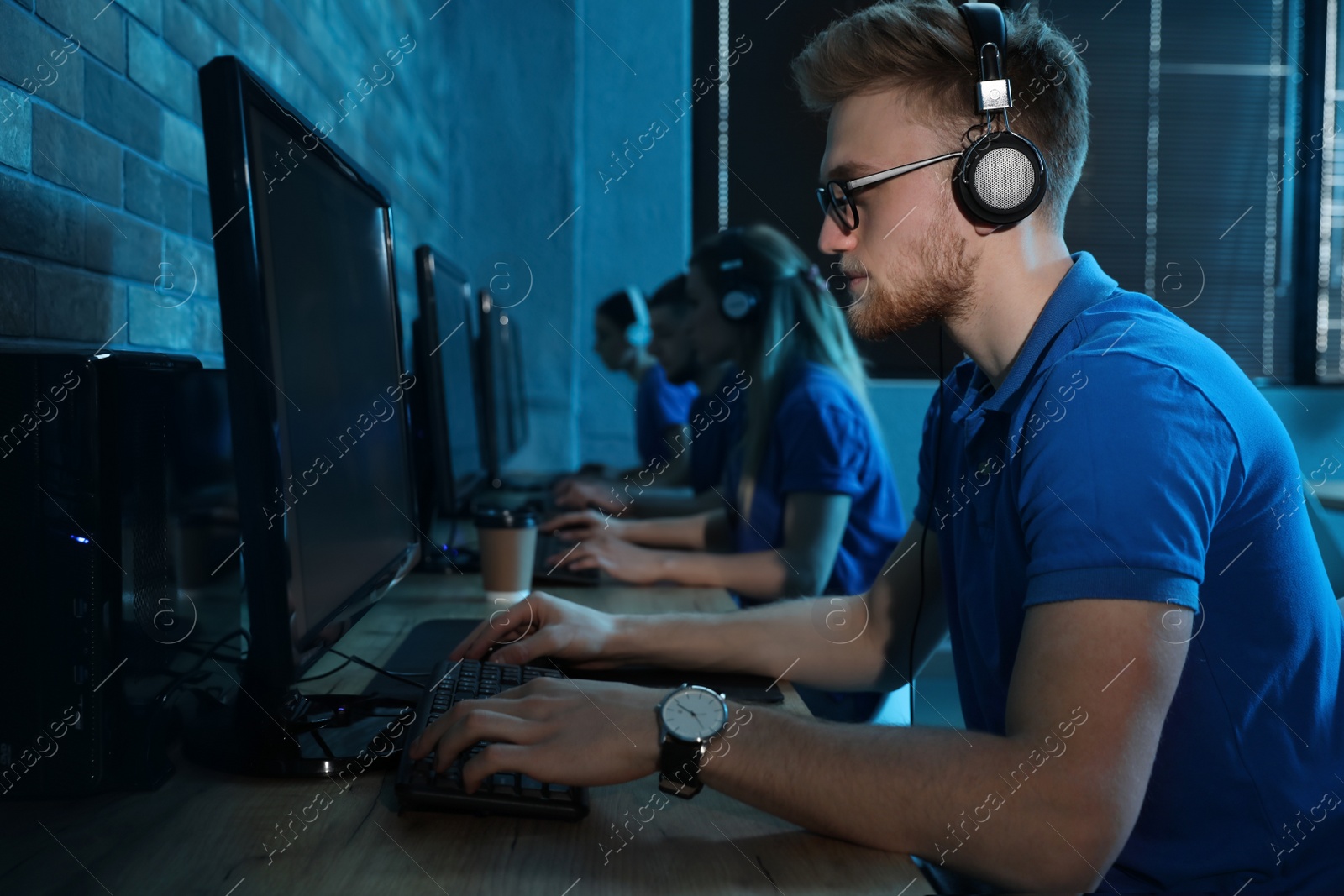 Photo of Man playing video game in internet cafe