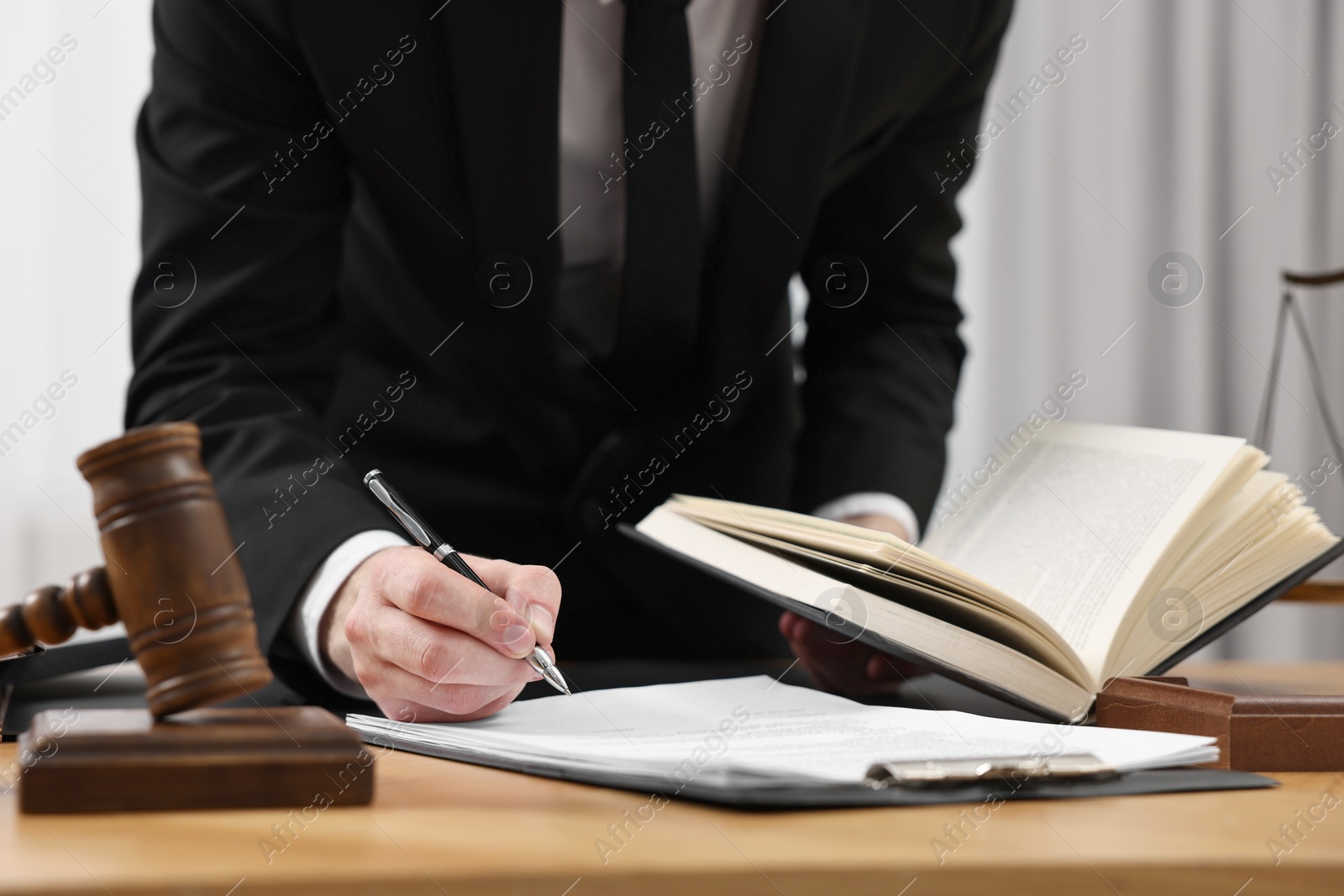 Photo of Lawyer working with documents at table indoors, closeup