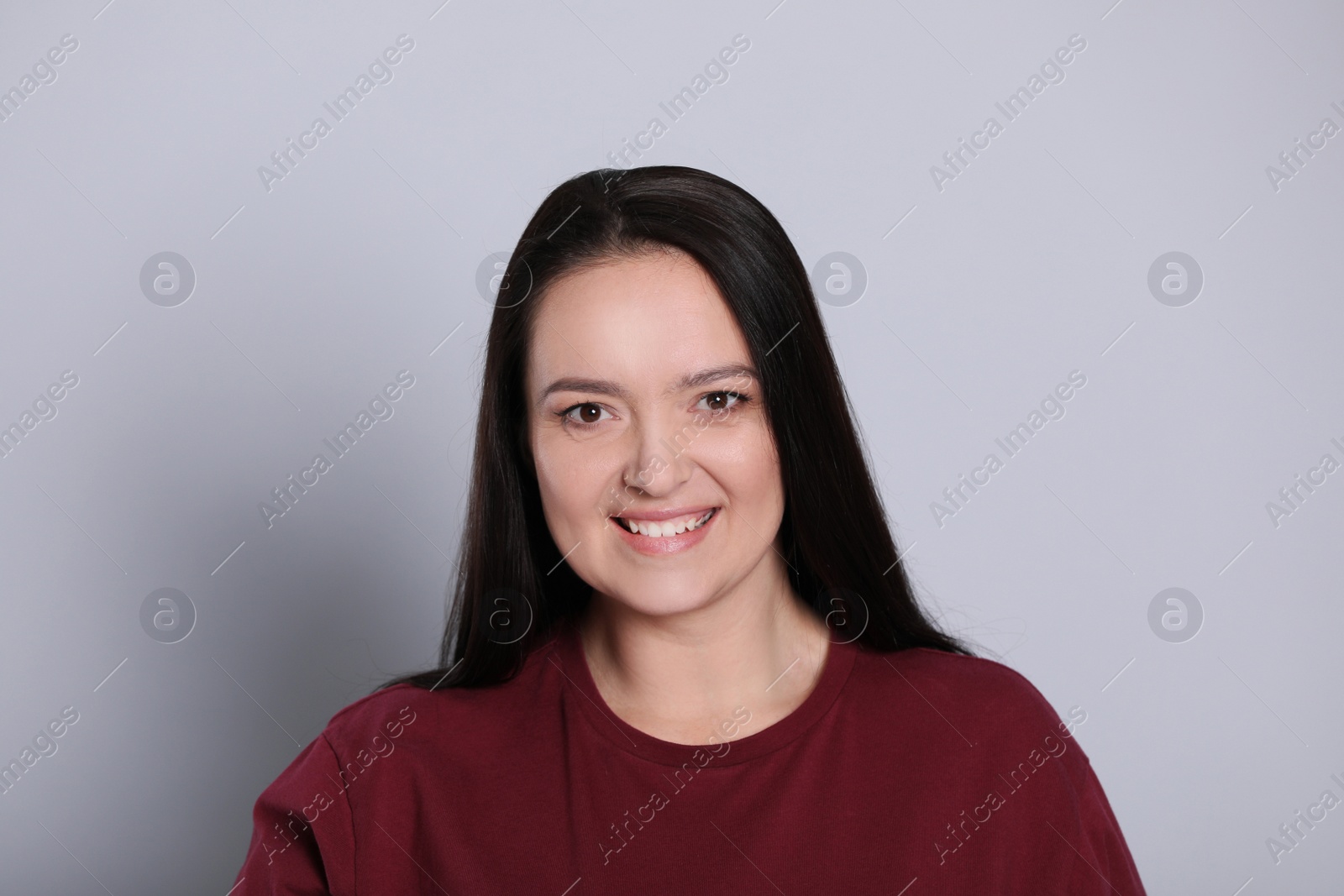 Photo of Beautiful overweight woman with charming smile on light grey background