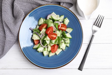 Flat lay composition with delicious fresh cucumber tomato salad on table