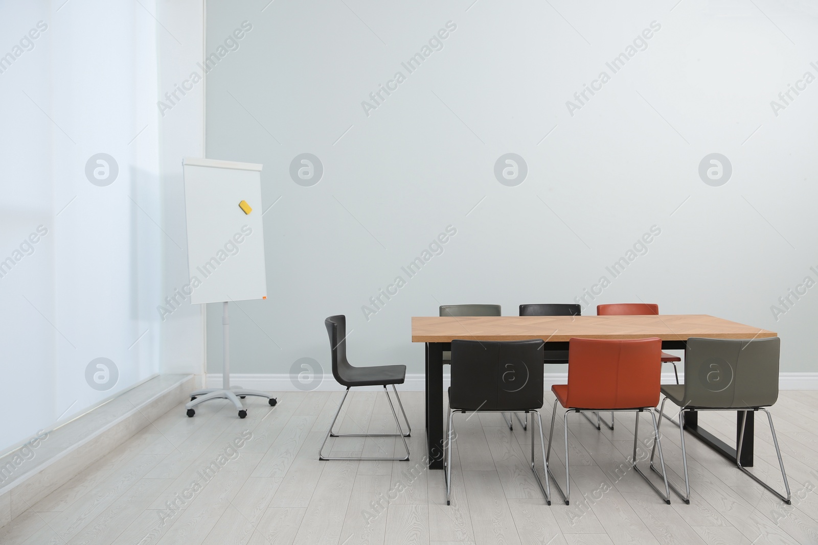 Photo of Conference room interior with wooden table and flipchart