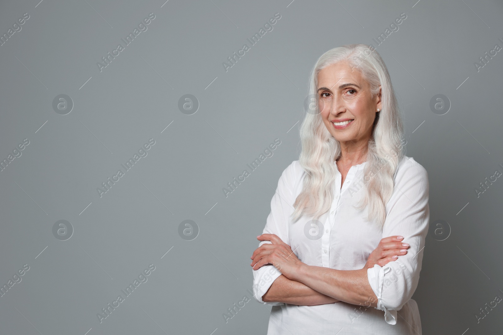 Photo of Portrait of beautiful mature woman on grey background, space for text