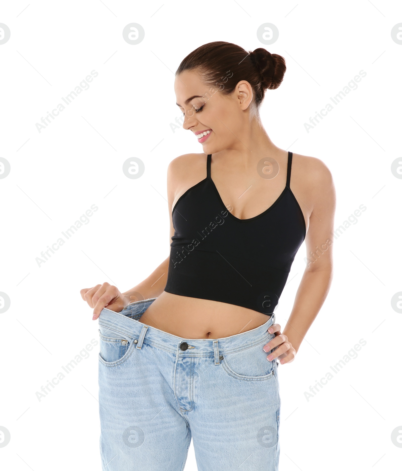 Photo of Slim woman in oversized jeans on white background. Weight loss