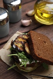Photo of Delicious fresh eggplant sandwich served on wooden table, closeup