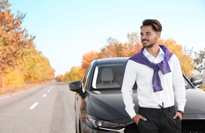 Young man near modern car on sunny day, outdoors