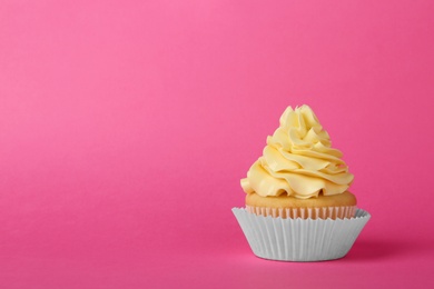 Tasty cupcake with cream on pink background, space for text