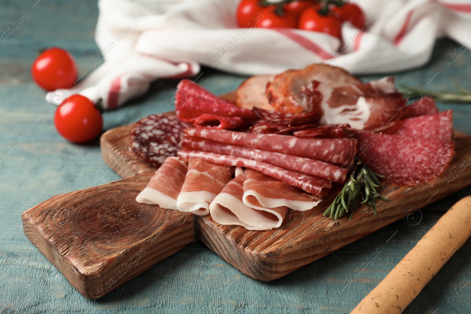 Photo of Cutting board with different sliced meat products served on table